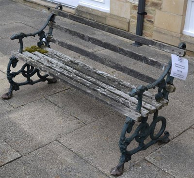 Lot 1189 - A Victorian wooden slatted cast iron garden bench with dog form arms, probably Coalbrookdale