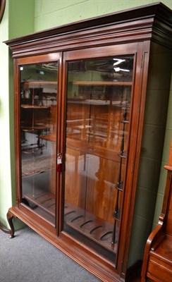 Lot 1291 - An early 20th century mahogany glazed gun cabinet, a bold cornice enclosing small shelves with...