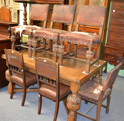 Lot 1295 - A matched dining suite comprising a carved oak and walnut sideboard, oak drawer leaf dining...