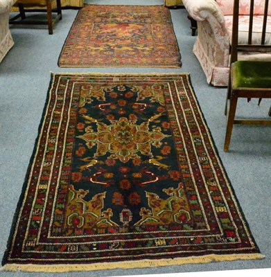 Lot 1332 - An Afghan Balouch rug, the field with a flowerhead medallion framed by spandrels and narrow...