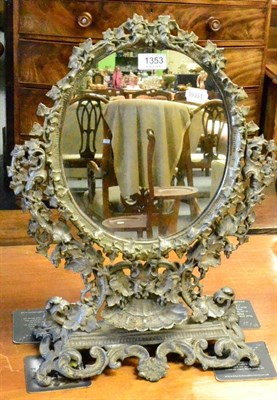 Lot 1353 - A 19th century cast iron toilet mirror with electrode foliate frame sconce