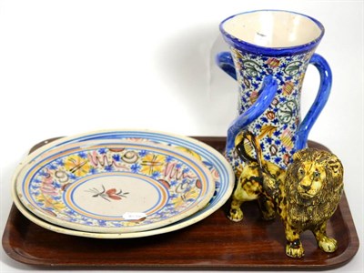 Lot 14 - A Cotswold Pottery lion, stamped; together with two Maiolica tin glazed dishes and a tyg (4)