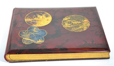 Lot 22 - A Japanese lacquer photograph album circa 1900, containing hand tinted topographical views of Japan