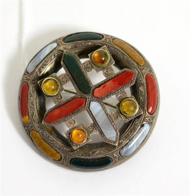 Lot 77 - A Scottish hardstone brooch, a central cross motif within a circular frame and set throughout...