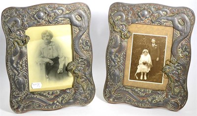 Lot 319 - A pair of Oriental photograph frames, circa 1900, decorated in relief with trailing dragons, 32cm