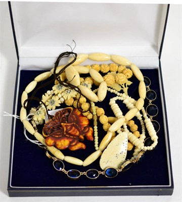 Lot 434 - A graduated blue paste riviere necklace, length 45cm, two carved bone necklaces and an...