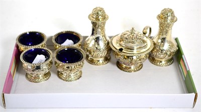 Lot 498 - A seven piece silver condiment set with repousse decoration