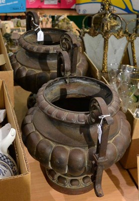 Lot 1056 - A pair of cast iron twin-handled garden urns (2)