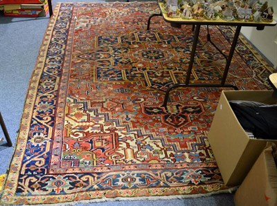 Lot 1103 - Heriz carpet, Iranian Azerbaijan, the brick red field of angular vines centred by an indigo...