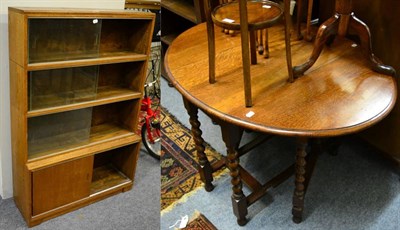 Lot 1122 - An oak gate leg dining table and a four tier bookcase