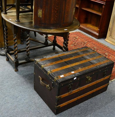 Lot 1128 - A 1920's oak gate leg dining table together with a wooden and metal bound travelling trunk