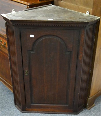 Lot 1151 - A George III oak hanging corner cupboard