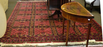 Lot 1239 - A machine made carpet of Turkman design, the brick red compartmentalised field enclosed by...