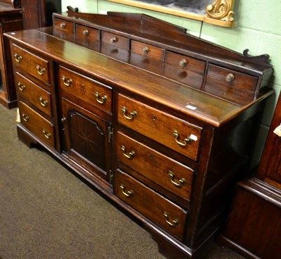 Lot 1248 - An oak dresser base, the back with a row of short drawers above an arrangement of drawers and...