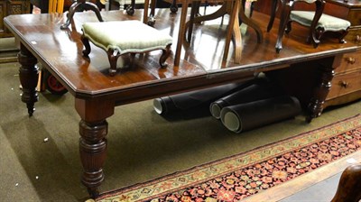 Lot 1287 - A late Victorian mahogany wind out dining table, on large turned fluted supports, with two...