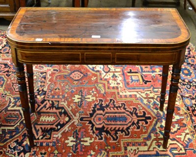 Lot 1311 - Regency mahogany D-shaped fold-over card table, cross-banded top on turned supports