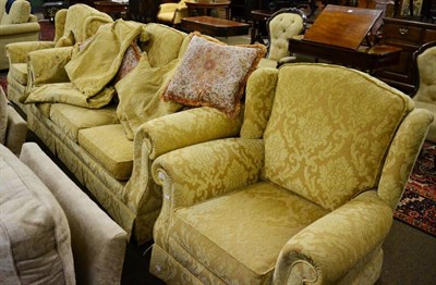 Lot 1315 - Three seater sofa and matching pair of armchairs, upholstered in gold foliate design fabric