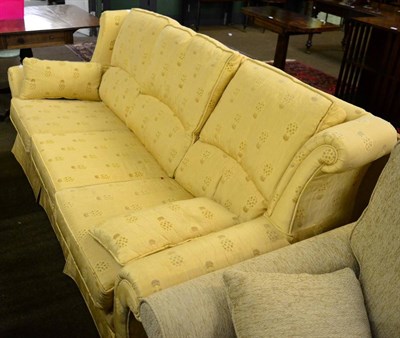 Lot 1339 - A three-seater sofa, upholstered in gold patterned fabric with rounded arm supports and three squab