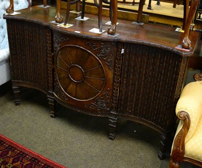 Lot 1346 - A George III mahogany bowfront sideboard, late 18th century, the central cupboard door...