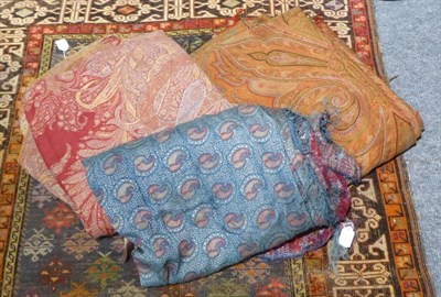 Lot 1419 - A large woven red ground paisley throw, another with a red centre, a smaller blue example (3)