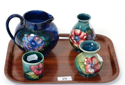 Lot 29 - Four pieces of Walter Moorcroft pottery, including Anenome pattern jug and vase and Hibiscus...