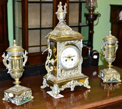 Lot 388 - A brass striking mantel clock with garniture, circa 1890