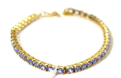 Lot 401 - A 9ct gold tanzanite line bracelet, 20cm long