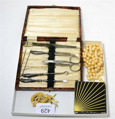 Lot 429 - A Christian Dior brooch, a simulated pearl necklace, two other brooches and a manicure set