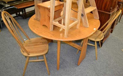 Lot 1141 - An Ercol light elm gate legged dining table, together with two similar chairs