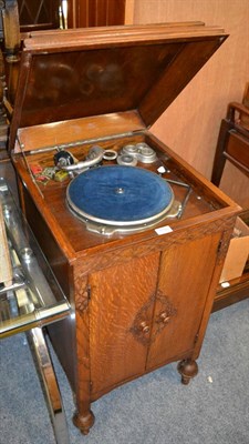 Lot 1150 - An oak cased gramophone cabinet together with a quantity of records