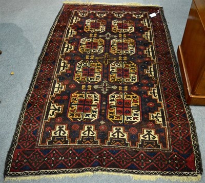 Lot 1287 - Balouch rug, Iranian/Afghan Frontier, the chocolate brown field with two rows of quartered...