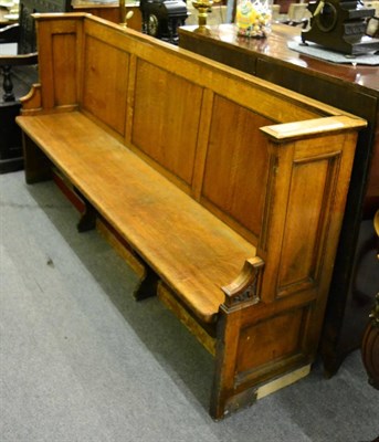 Lot 1291 - An oak panel backed settle