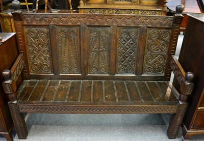 Lot 1330 - An oak settle with carved decoration