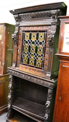 Lot 1354 - A Victorian ornately carved oak bookcase cabinet, the upper section with leaded coloured glass door