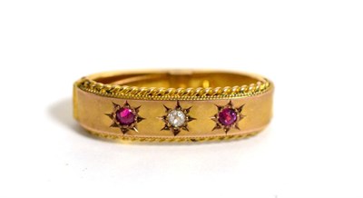 Lot 38 - A 9ct gold diamond and ruby scarf clip, an old cut diamond between two round cut rubies in star...