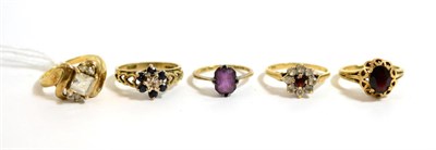 Lot 68 - A 9ct gold garnet ring, three 9ct gold cluster rings and a purple stone ring (5)