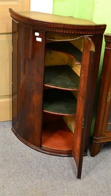 Lot 1216 - A Georgian mahogany bow fronted hanging corner cabinet