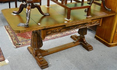 Lot 1227 - A carved oak draw leaf table