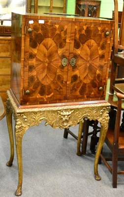 Lot 1241 - A William & Mary style yew oyster veneered cabinet, on later gilt stand with mask decoration...