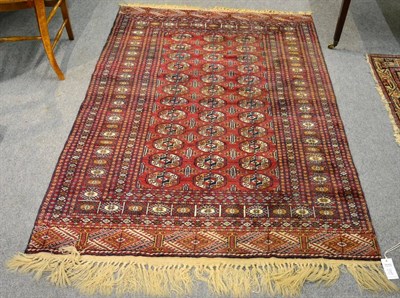 Lot 1247 - A ";Bakhara"; rug, North Afghanistan, the burgundy field with three rows of guls enclosed by...