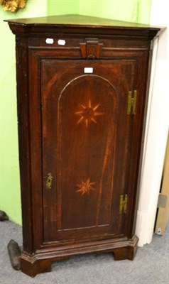 Lot 1311 - A Georgian cross banded oak floor standing corner cupboard