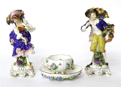 Lot 3 - A Meissen floral encrusted teacup and saucer and a pair of Continental porcelain figures of...