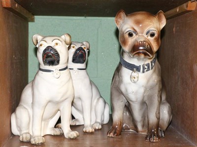 Lot 117 - Pair of 19th century Staffordshire seated pugs with separated forelegs and a single example