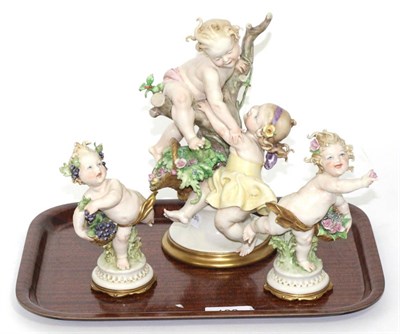 Lot 186 - A Capodimonte cherub with grapes together with cherub with flowers and cherubs around the tree;...