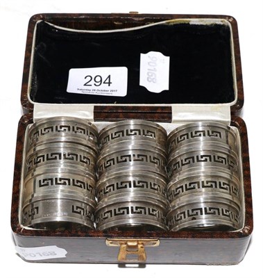 Lot 294 - A set of twelve silver napkin rings with pierced Greek key decoration