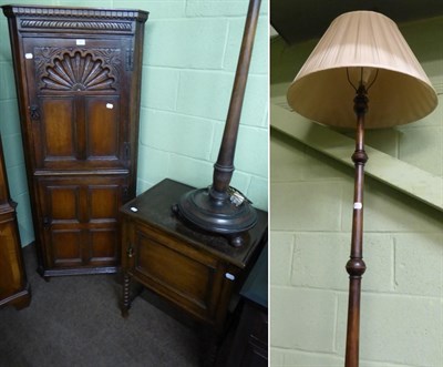 Lot 583 - A reproduction oak standing corner cupboard, a 1920's oak bedside cupboard and a standard lamp