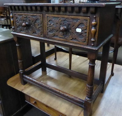 Lot 616 - A carved oak side table fitted with two drawers