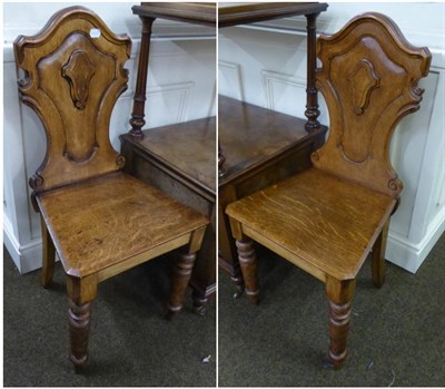 Lot 641 - A pair of oak shield back hall chairs