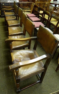 Lot 654 - A set of six 1920's oak framed studded leather dining chairs including two carvers