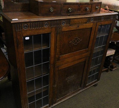 Lot 683 - A 1920's oak cabinet with twin leaded glass doors